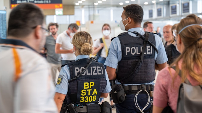 Eine Beamtin und ein Beamter der Bundespolizei gehen durch den Flughafen Köln/Bonn.