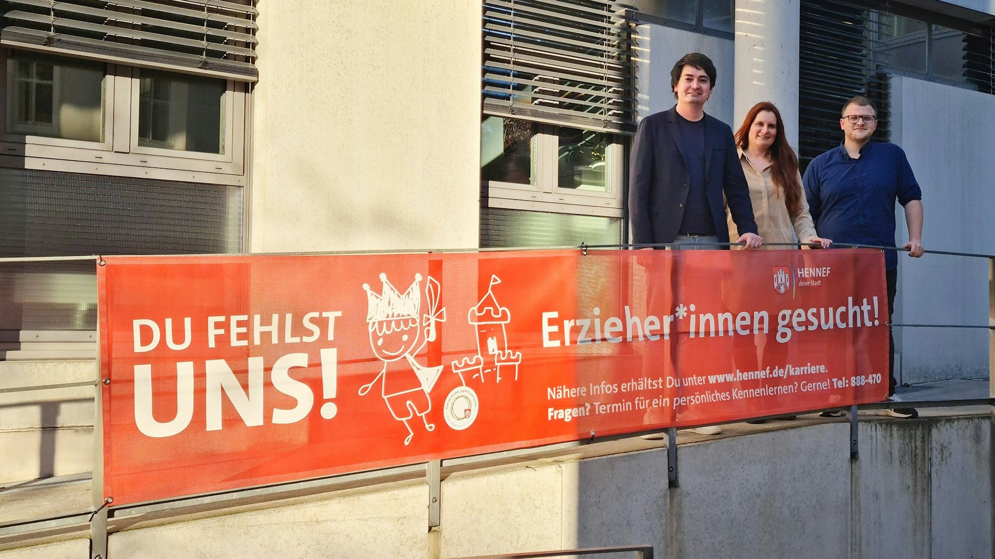 Bürgermeister Mario Dahm, Jugendamtsleiterin Miriam Overath und Erzieher Tom Ullrich (v.l.) mit einem Plakat.