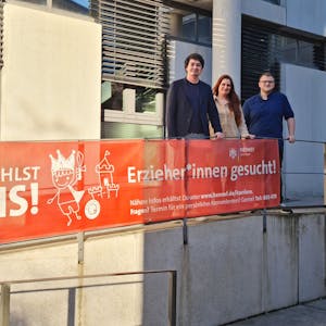 Bürgermeister Mario Dahm, Jugendamtsleiterin Miriam Overath und Erzieher Tom Ullrich (v.l.) mit einem Plakat.