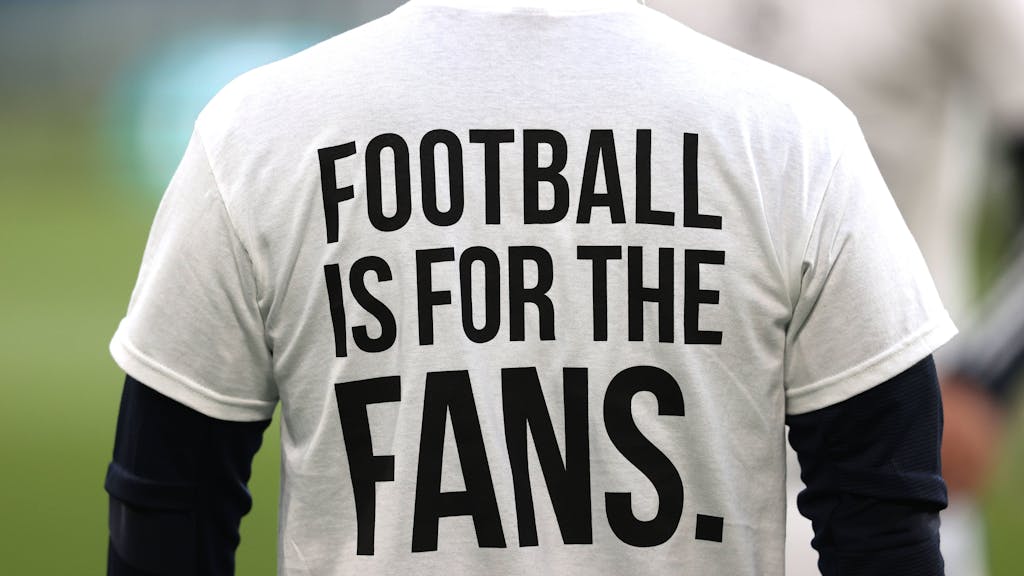 Ein Fan trägt ein T-Shirt mit der Aufschrift „FOOTBALL IS FOR THE FANS“.