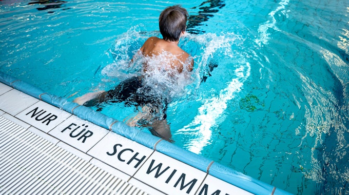 Ein Kind schwimmt im Stadtbad Märkisches Viertel. Auf den Fliesen steht die Aufschrift "nur für Schwimmer".