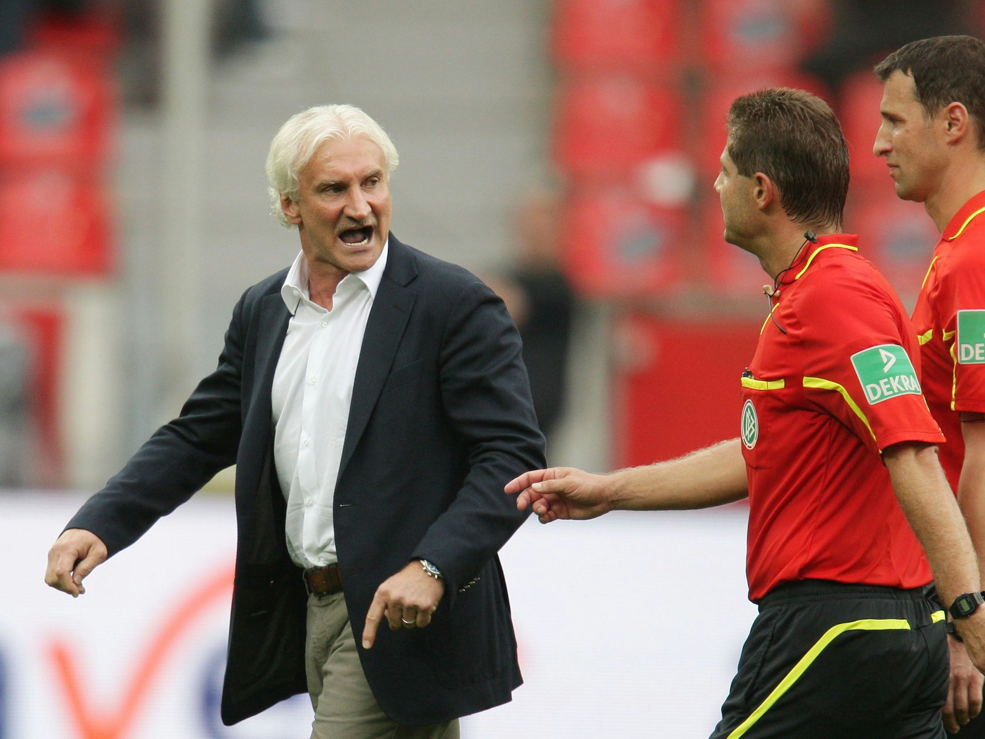 Bayer Leverkusens Ex-Sportdirektor Rudi Völler (l) diskutiert heftig mit Schiedsrichter Günter Perl bei der Begegnung gegen den FC.
