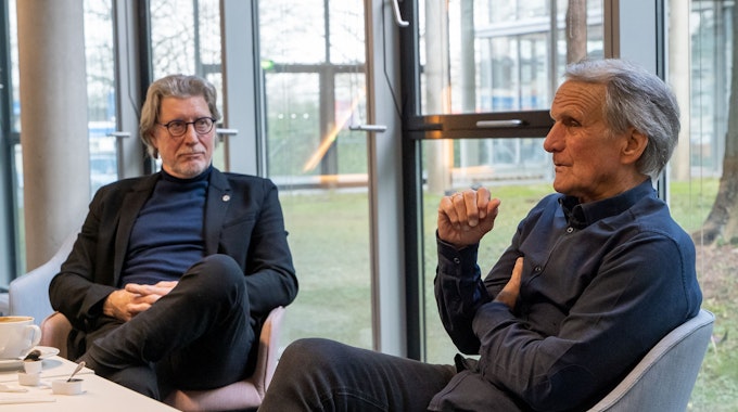 Toni Schumacher (links) und Wolfgang Overath reflektieren beim Gespräch und bei einer Tasse Kaffee alte Zeiten.