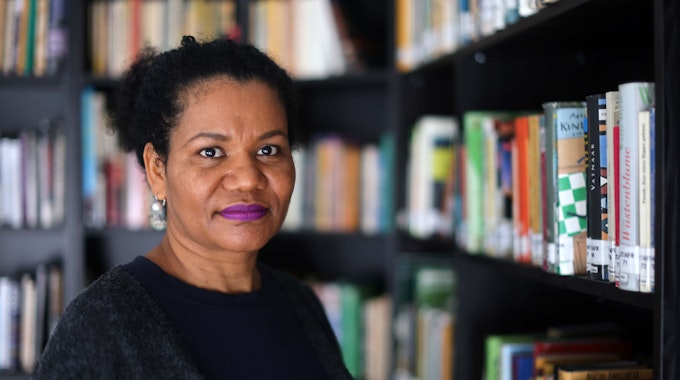 Glenda Obermuller steht vor einem Regal mit Schwarzer Literatur