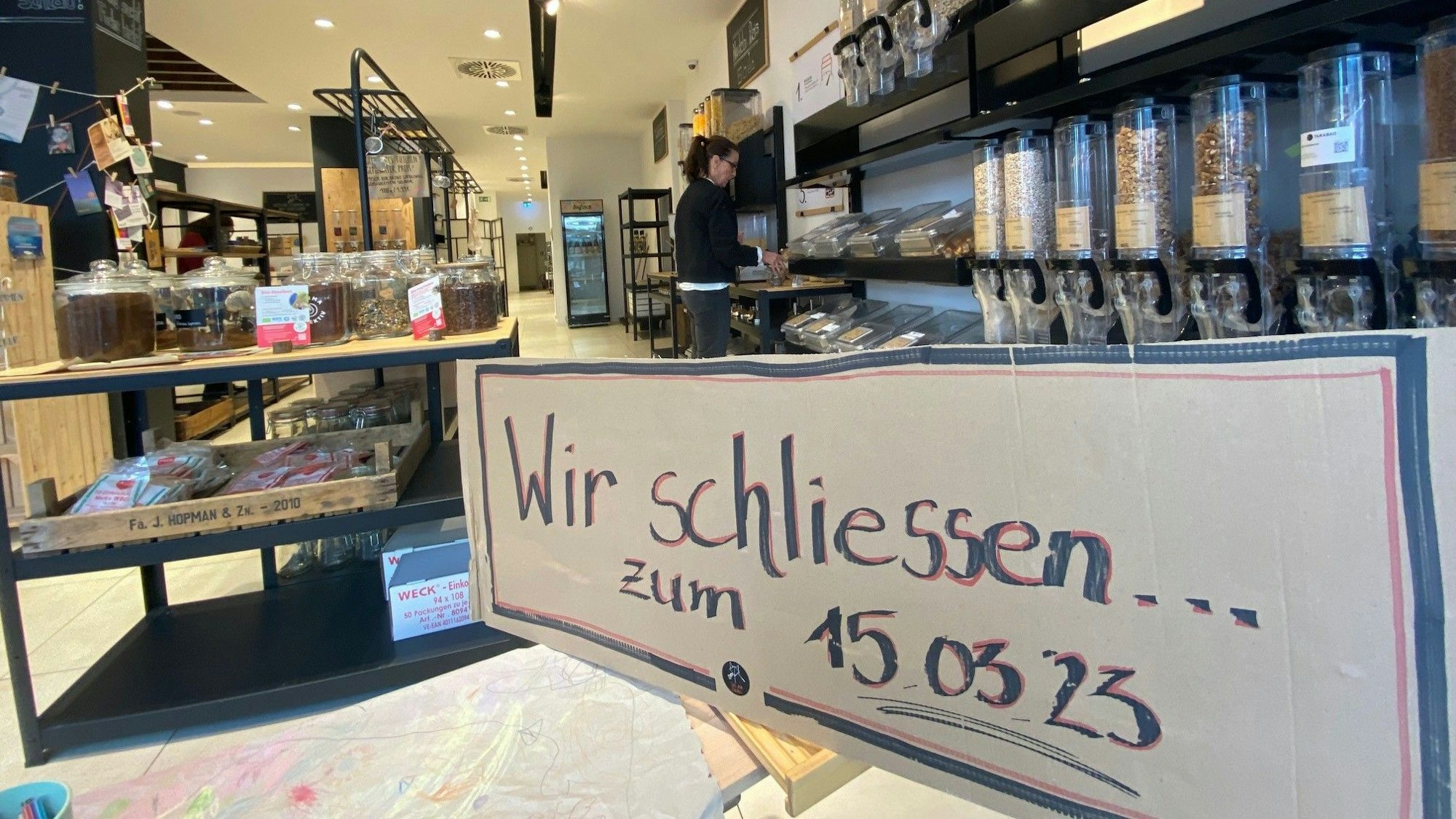 Das Foto zeigt ein Schild im Schaufenster des Ladens „Fette Beute“ in Brühl. Darauf steht „Wir schließen zum 15. März 2023“.