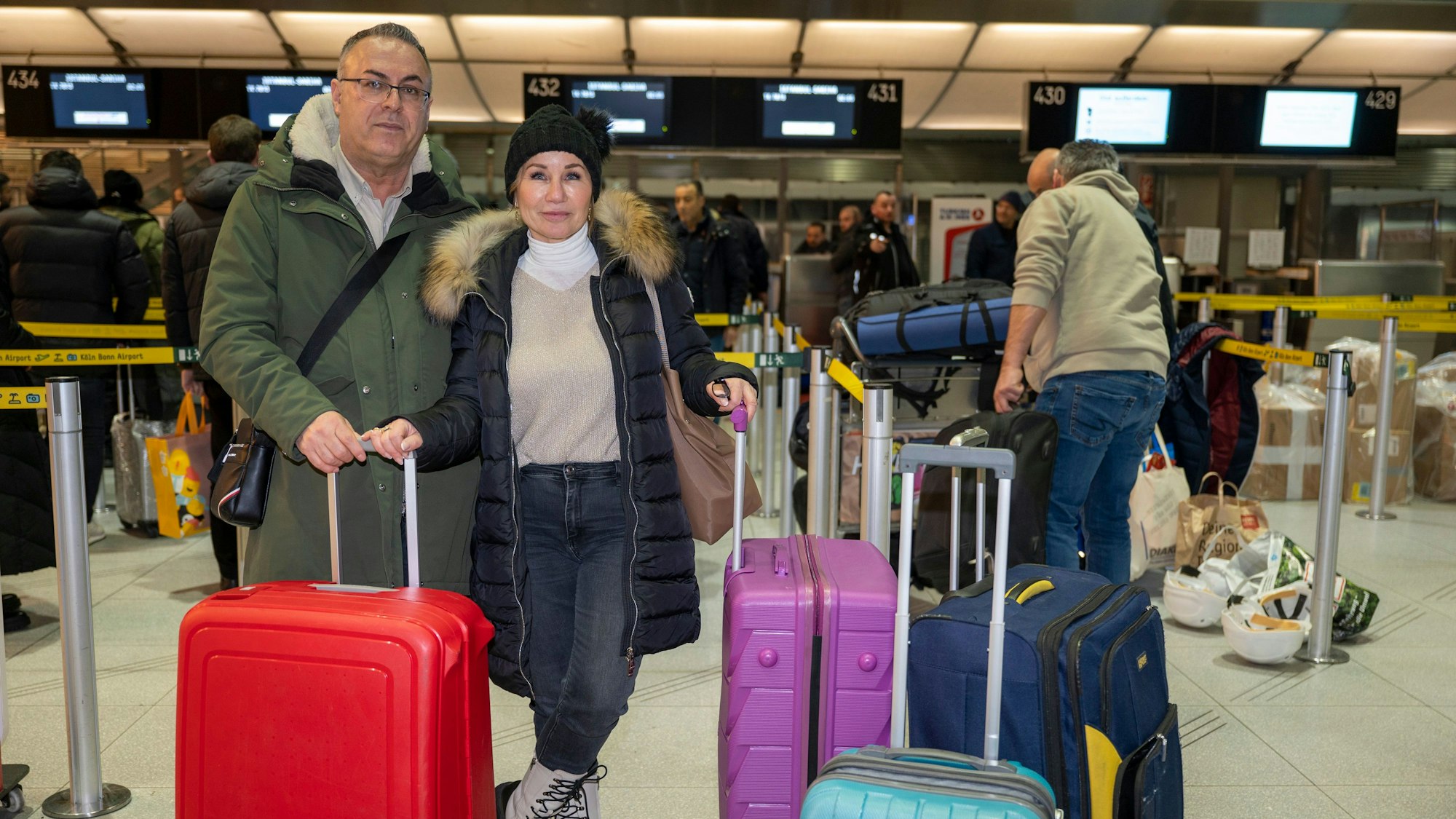 Edip Ercosman und seine Frau Nese Draeger stehen mit ihren vier Koffern vor dem Check-in in Terminal 2 am Flughafen Köln/Bonn.