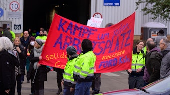 Ford-Mitarbeiter mit Streikplakat mit der Aufschrift „Kampf um jeden Arbeitsplatz“.