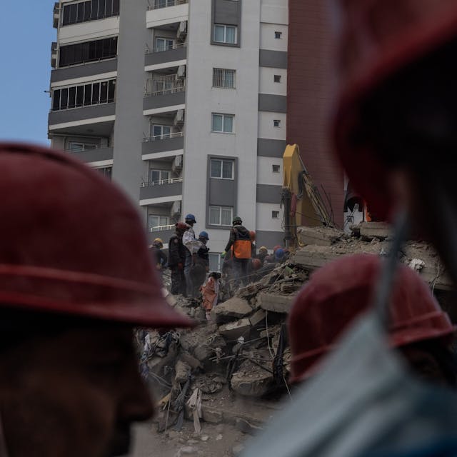Trümmer nach dem Erdbeben. Helfer mit roten Helmen sind vor Ort (Symbolbild)