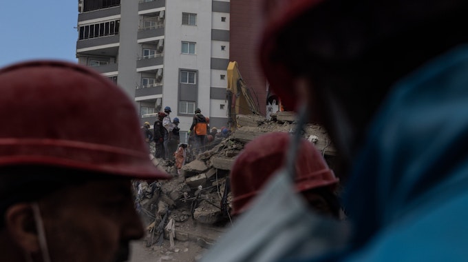 Trümmer nach dem Erdbeben. Helfer mit roten Helmen sind vor Ort (Symbolbild)
