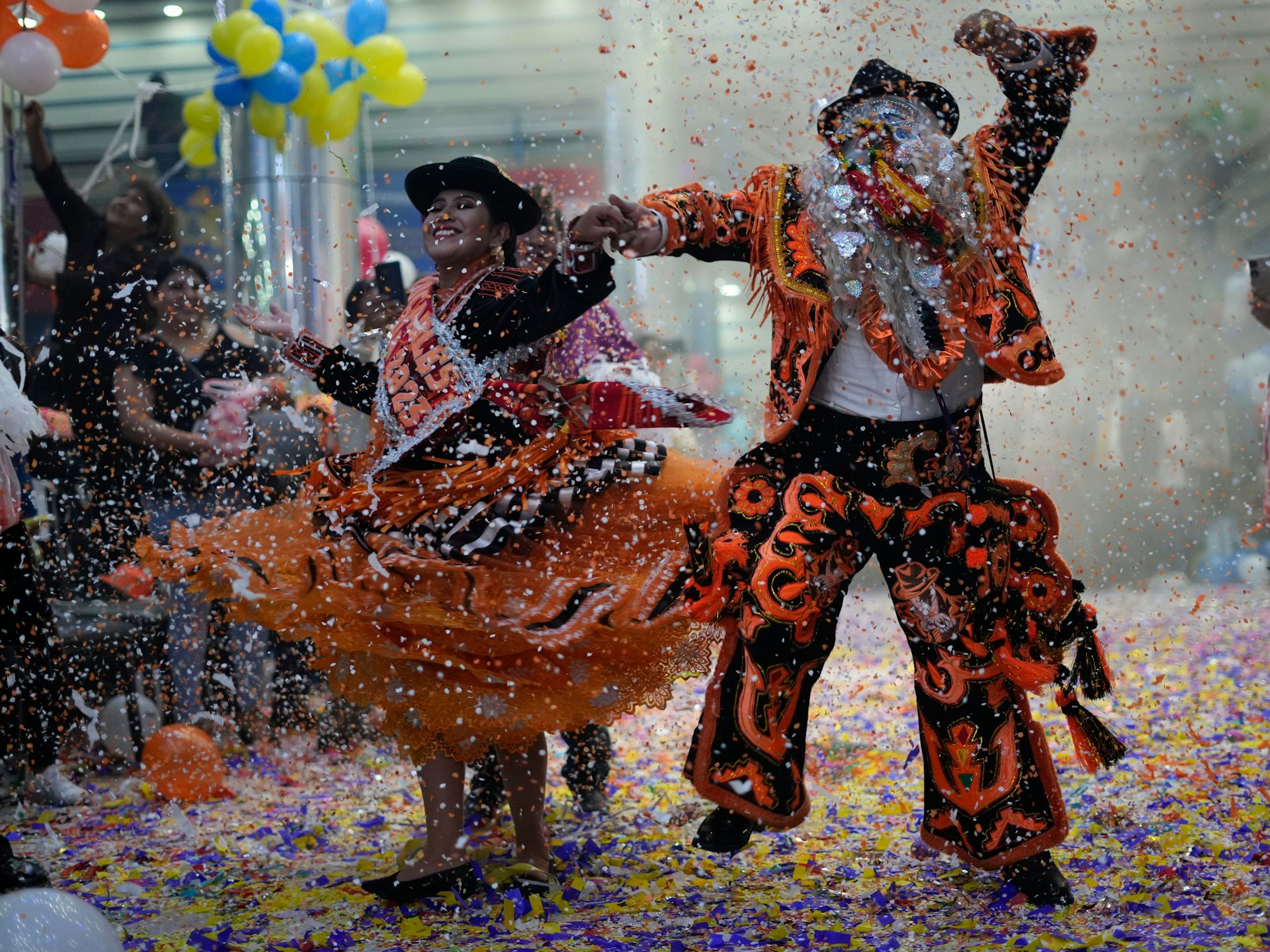 Ein kostümiertes Paar tanzt beim Karneval in Bolivien.