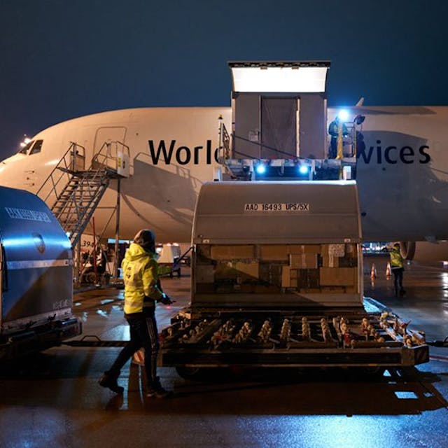 Eine UPS-Maschine aus Venedig wird nachts am Flughafen ausgeladen. Ein Container mit tausenden Paketen wird auf einen Autoanhänger geladen.