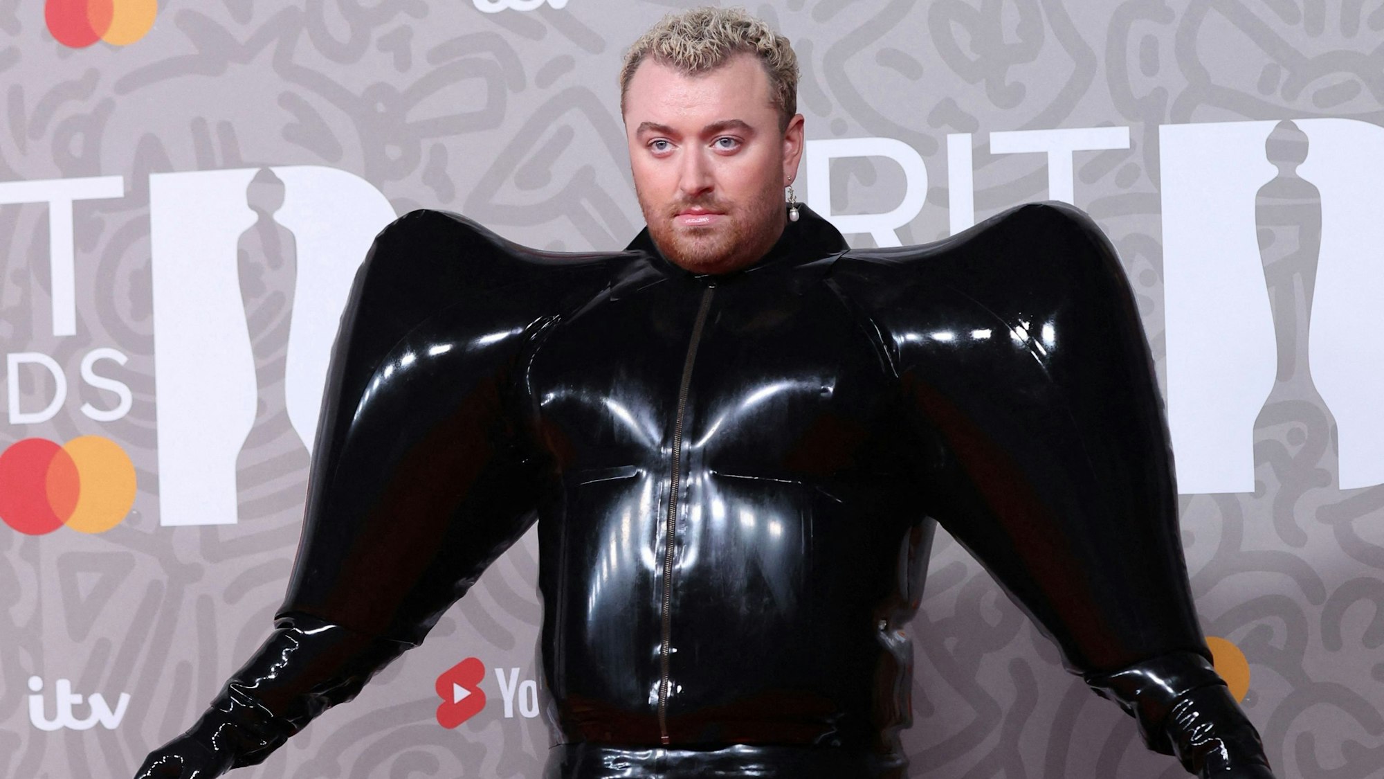 Sänger Sam Smith posiert im schwarzen Fantasy-Kostüm auf dem Roten Teppich bei den Brit Awards 2023