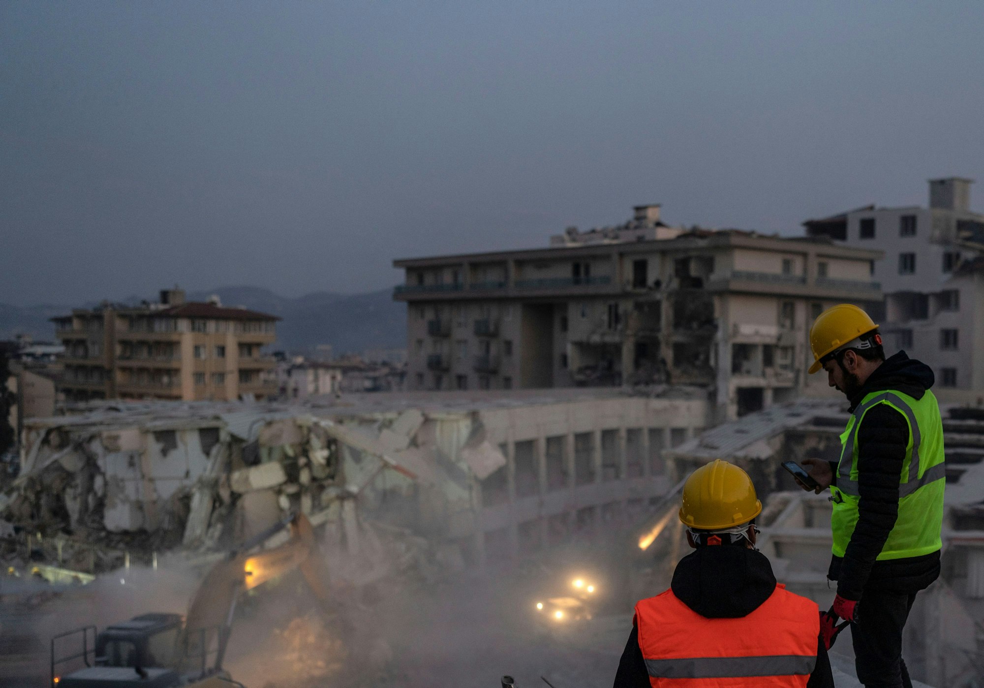 Rettungskräfte inspizieren auf der Suche nach den Opfern und Überlebenden des Erdbebens die Überreste eines zerstörten Gebäudes. Die Zahl der Toten nach den verheerenden Erdbeben im türkisch-syrischen Grenzgebiet ist auf mehr als 25 000 gestiegen.