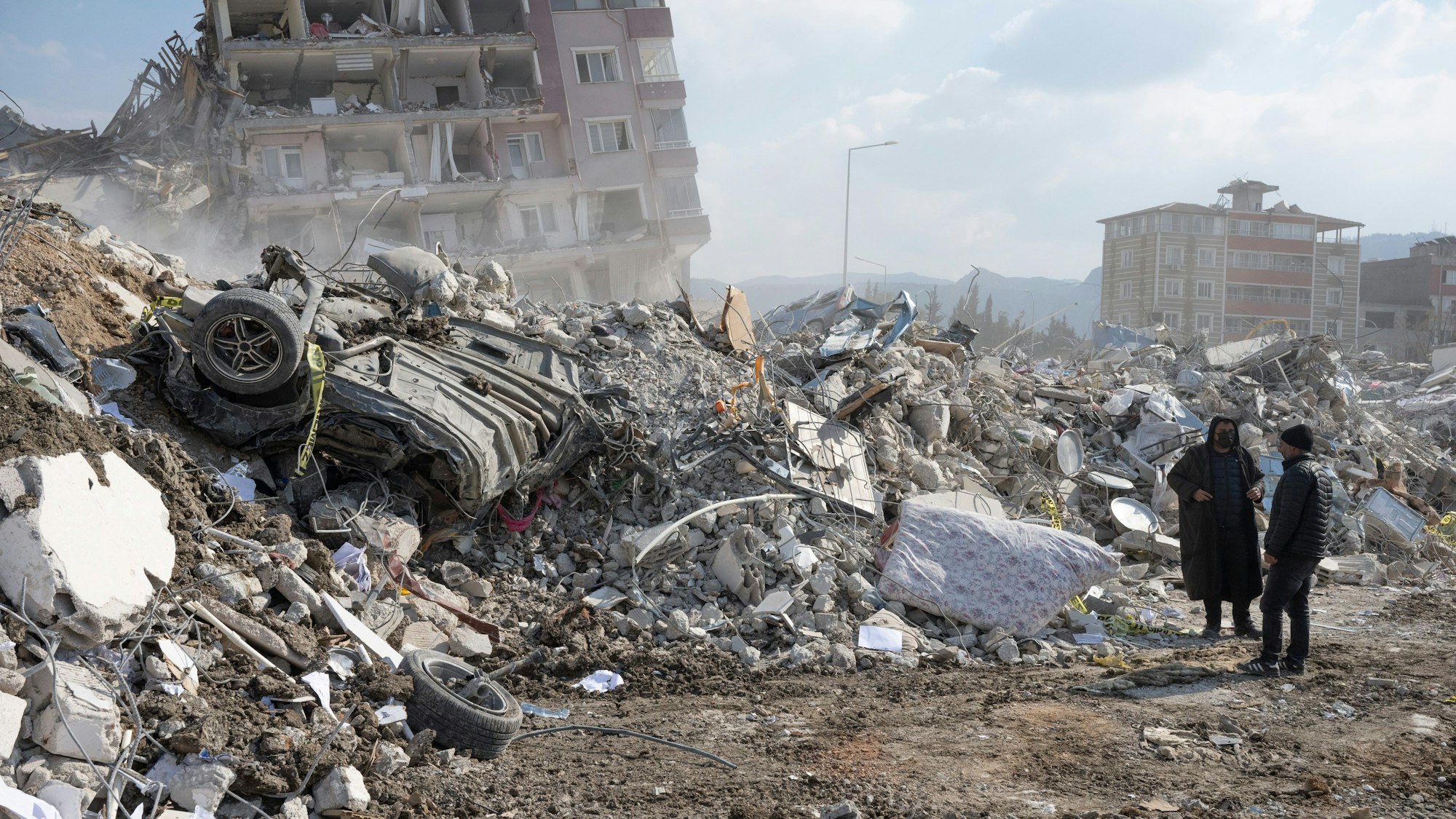 Anwohner gehen durch die Trümmer ihrer Häuser in Antakya.