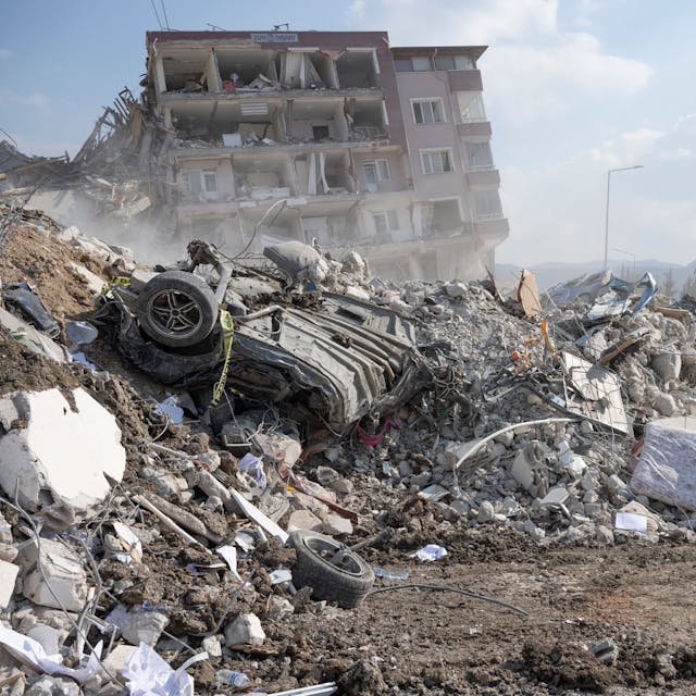 Anwohner gehen durch die Trümmer ihrer Häuser in Antakya.