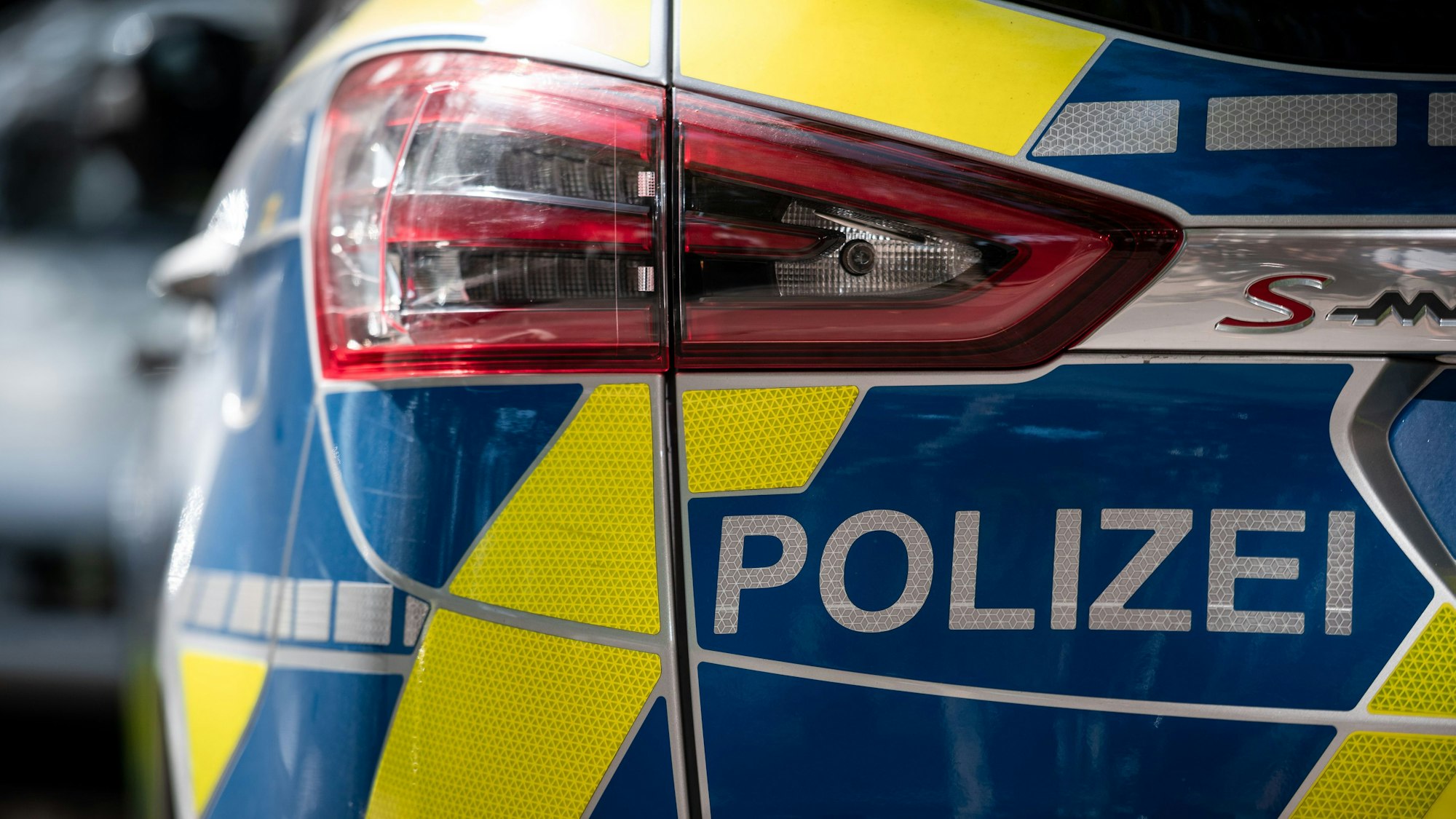 Das Foto zeigt einen Polizeiwagen von hinten. Die Polizei im Rhein-Erft-Kreis fahndet nach Tätern, die in Frechen und Bedburg Luxus-Autos gestohlen haben.
