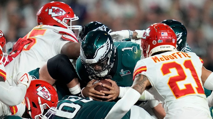 Eagles-Quarterback Jalen Hurts wirft sich beim Super Bowl mit dem Ball in der Hand ins Getümmel.