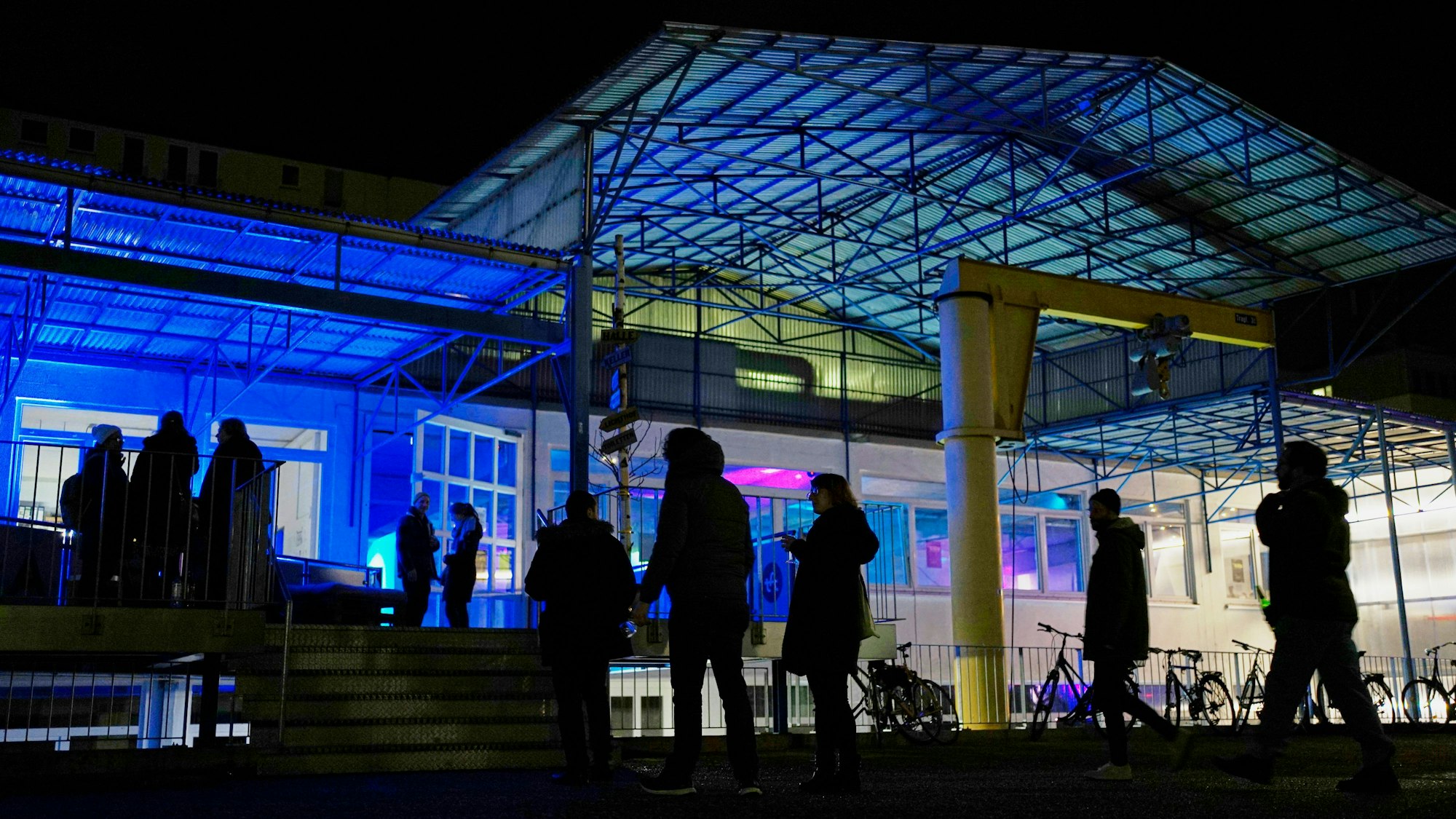 Die Spielstätte der TanzFaktur in Köln am Abend von außen fotografiert, mit bunter Beleuchtung und Gästen
