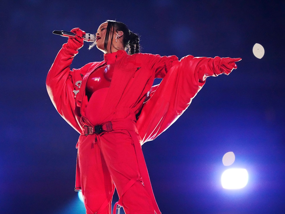 Rihanna performt in der Halftime-Show bei Super Bowl in einem roten Outfit.