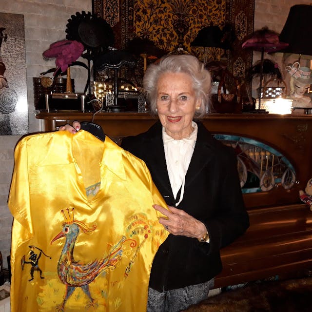 Melitta Erven hält die gelbe Bluse hoch, die Wolf Vostell für sie karnevalistisch bemalt hat.