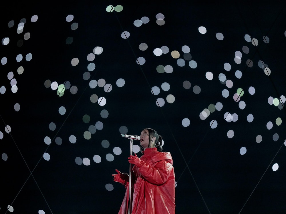 Rihanna singt mit Augen zu ins Mikrofon, im Hintergrund sind zahlreiche Taschenlampen der Zuschauer zu sehen.