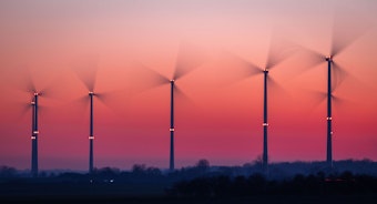Die Rotoren von Windkraftanlagen drehen sich nach Sonnenuntergang.
