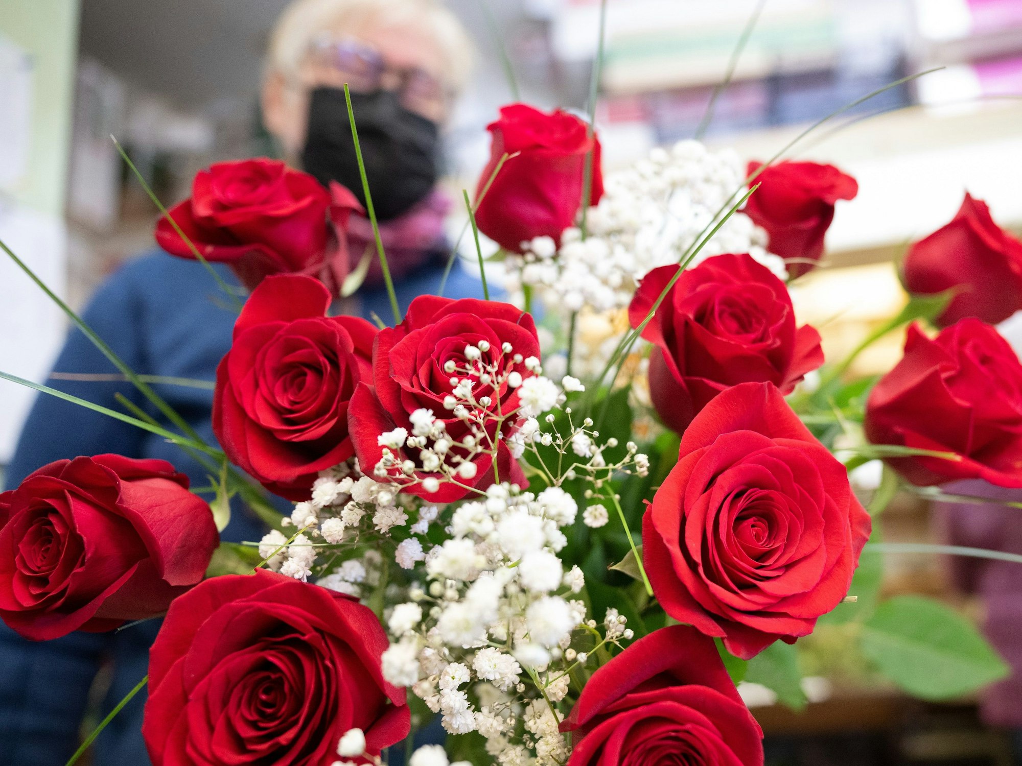 Ein Valentinstagsstrauß aus roten Rosen wird in einem Blumengeschäft gebunden.