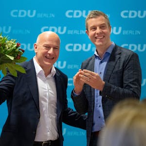 Kai Wegner (l), Landesvorsitzender CDU Berlin hält neben Stefan Evers, CDU-Generalsekretär, lachend einen Blumenstrauß in der Hand.
