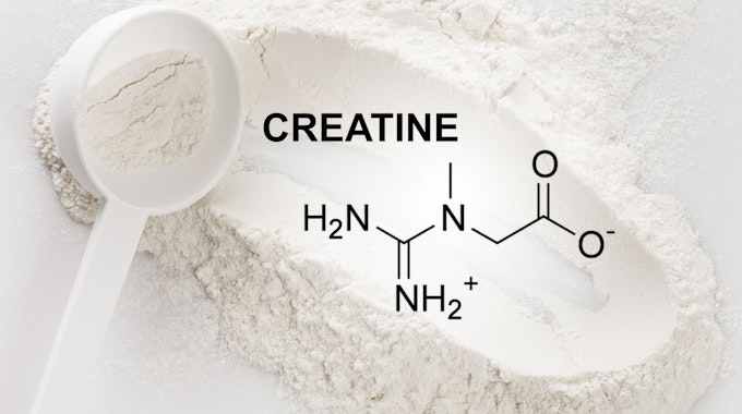 Closeup of scoop with creatine monohydrate supplement and chemical formula