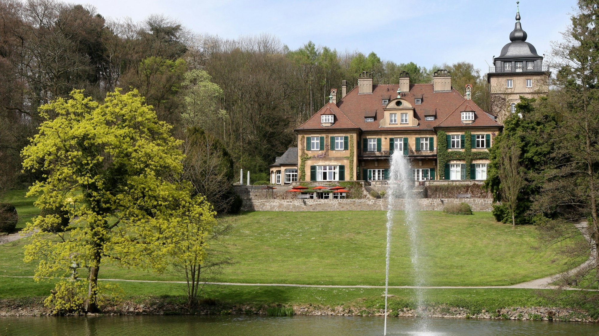 Schloss Lerbach mit Grünanlage und Teich davor.