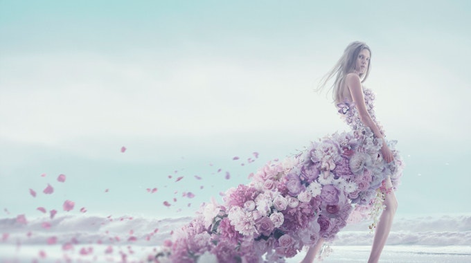 Eine junge Frau in einem Blütenkleid am Strand