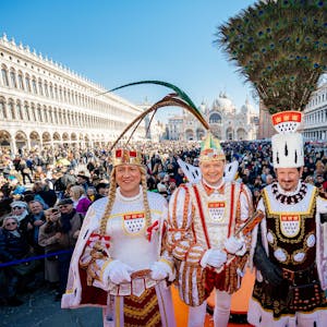 Auftritt auf dem Markusplatz: Das Dreigestirn der Roten Funken grüßt die Feiernden im italienischen Venedig.