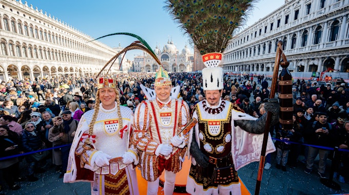 Auftritt auf dem Markusplatz: Das Dreigestirn der Roten Funken grüßt die Feiernden im italienischen Venedig.