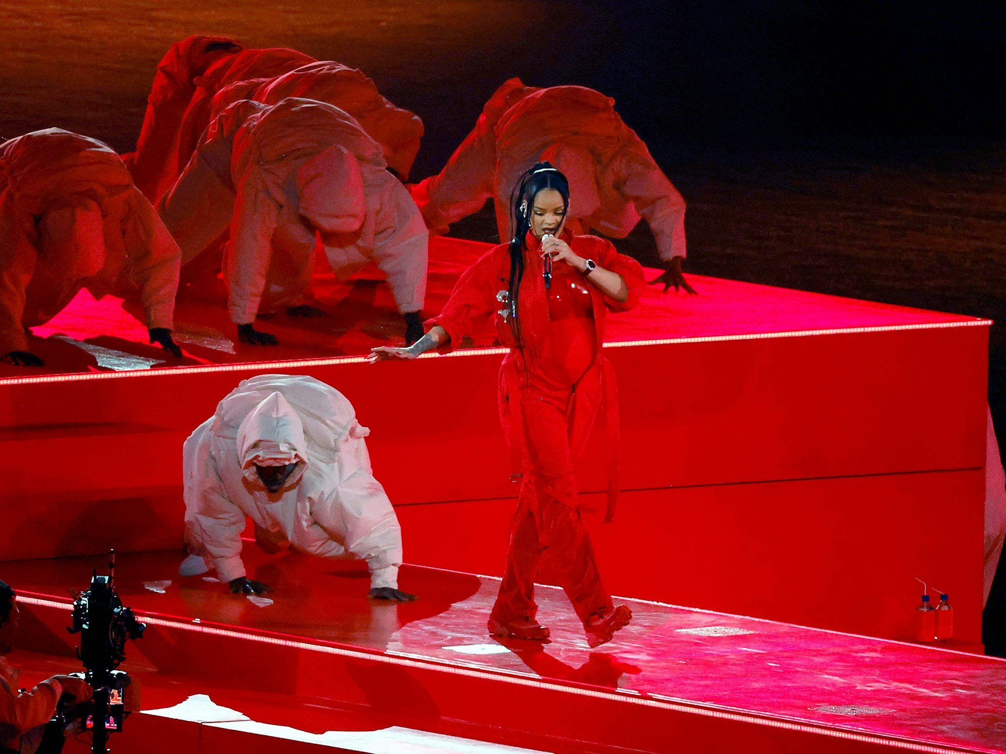 Rihanna geht singend auf einem Steg entlang.