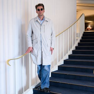 Marco Goecke, Ballettdirektor der Staatsoper Hannover, steht im Foyer der Staatsoper. Er trägt einen hellen Trenchcoat und eine Sonnenbrille.