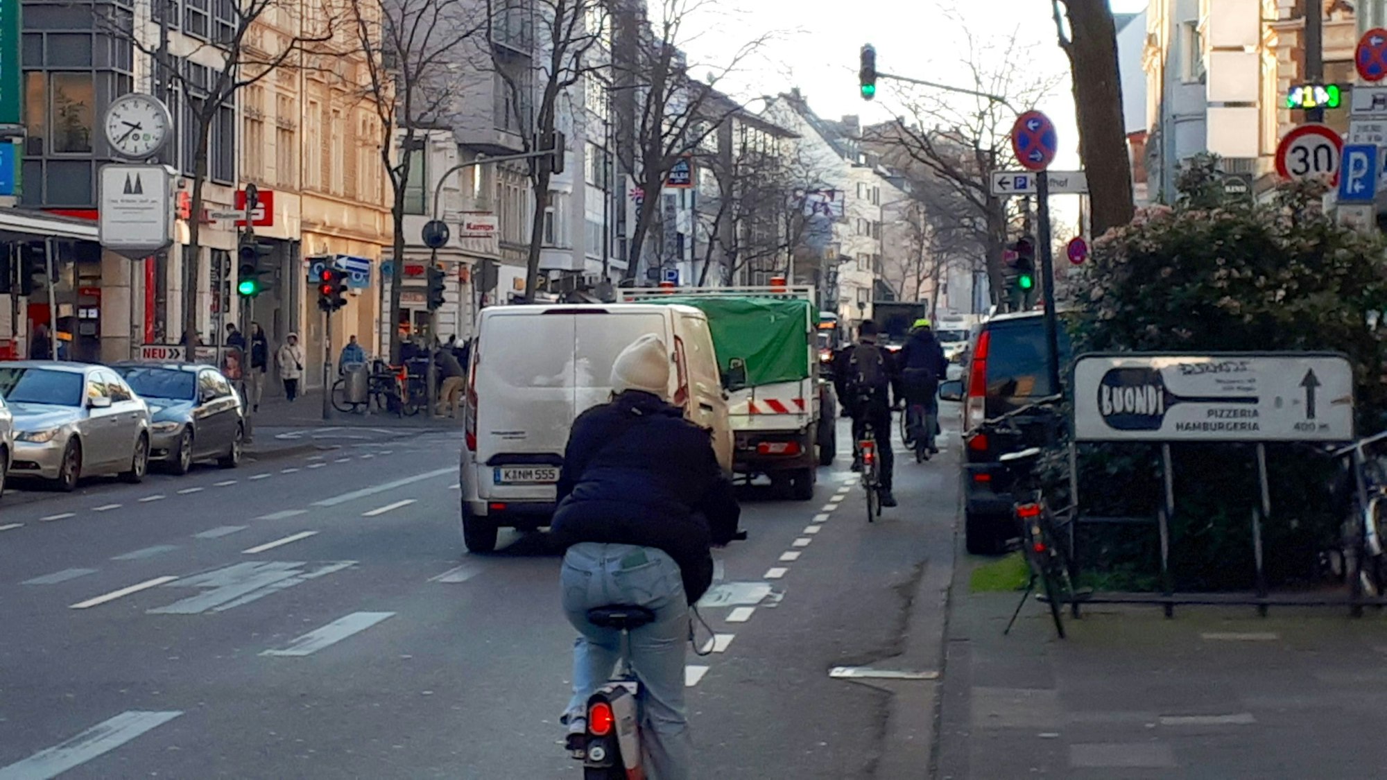 Fahrradfahrer und Autos fahren über die Neusser Straße