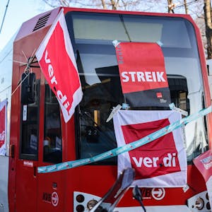 Eine mit Streik-Plakaten beklebte Straßenbahn der Kölner Verkehrs-Betriebe (KVB) steht vor dem Bahndepot.