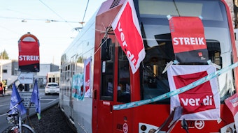 Eine mit Streik-Plakaten beklebte Straßenbahn der Kölner Verkehrs-Betriebe (KVB) steht vor dem Bahndepot.