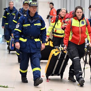 Rettungskräfte werden von jubelnden Menschen auf dem Flughafen in Köln begrüßt.