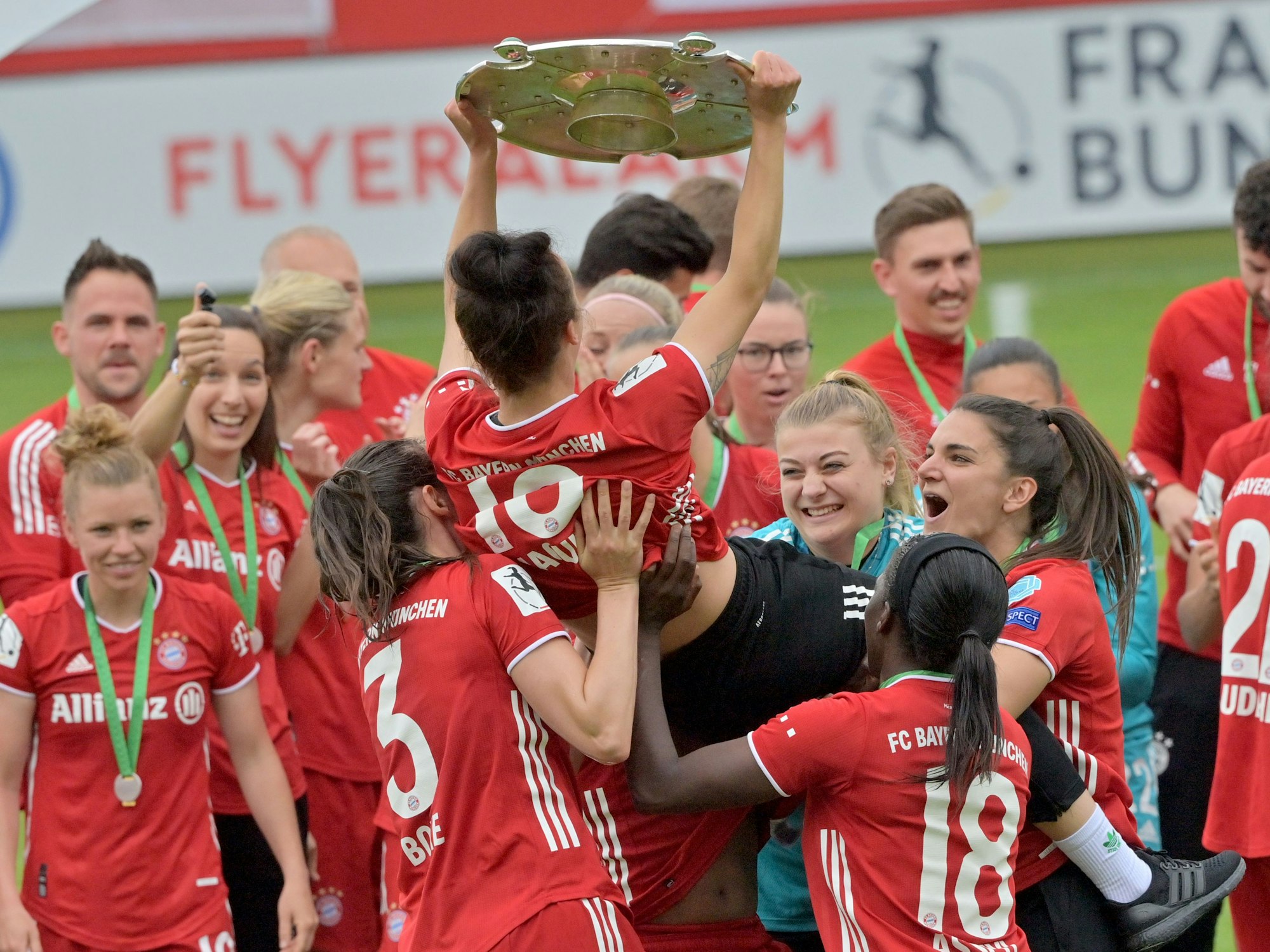 Die Spielerinnen vom FC Bayern München jubeln nach Spielende über den Sieg und über die Deutsche Meisterschaft mit der Meisterschale. 
