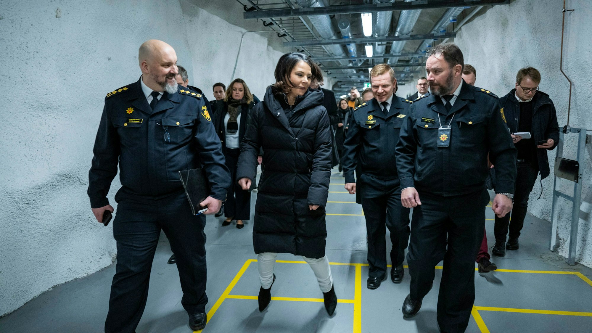 Annalena Baerbock (Bündnis 90/Die Grünen, M), Außenministerin, besucht eine Zivilschutzanlage in der Innenstadt und springt auf den aufgemalten Quadraten auf dem Boden.