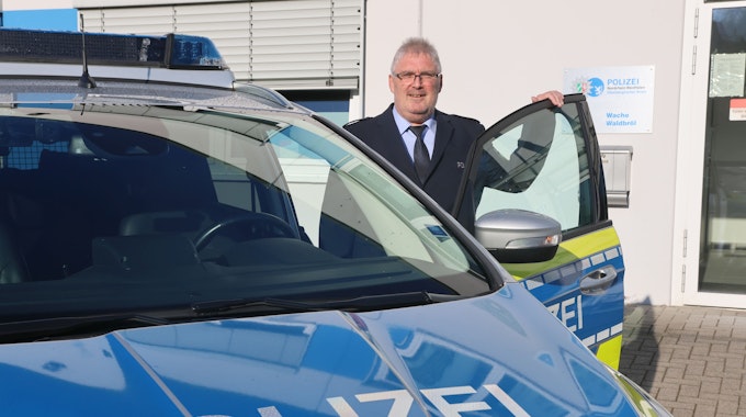 Der neue Wachleiter Falko Steinhauer steht an einem Streifenwagen.