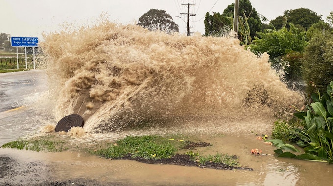 Wasser sprudelt aus einer Regenwasseröffnung in einer Straße in Te Awanga, südöstlich von Auckland. Die neuseeländische Regierung hat über die vom Zyklon Gabrielle heimgesuchte Nordinsel den Ausnahmezustand verhängt.