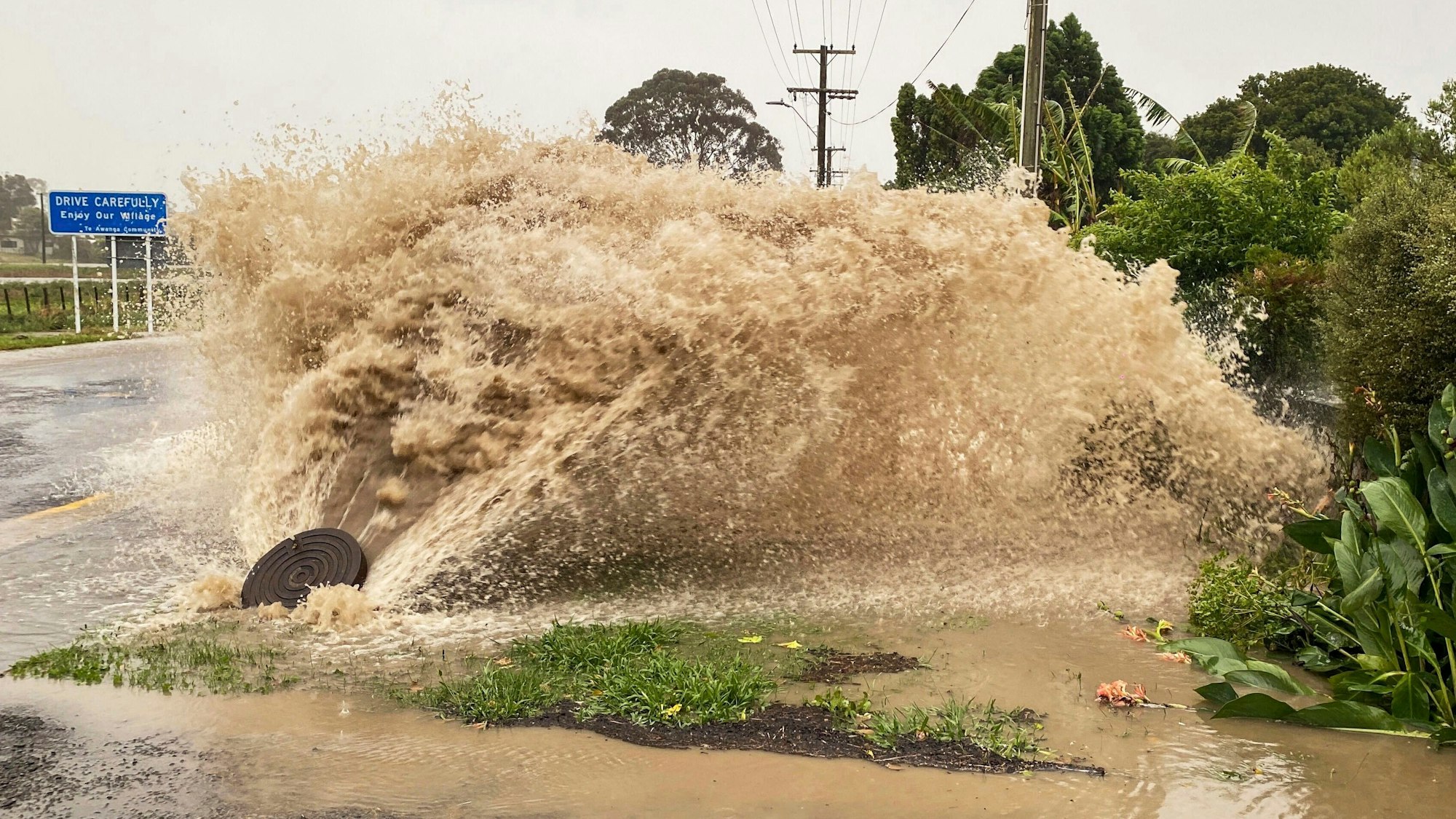 Wasser sprudelt aus einer Regenwasseröffnung in einer Straße in Te Awanga, südöstlich von Auckland