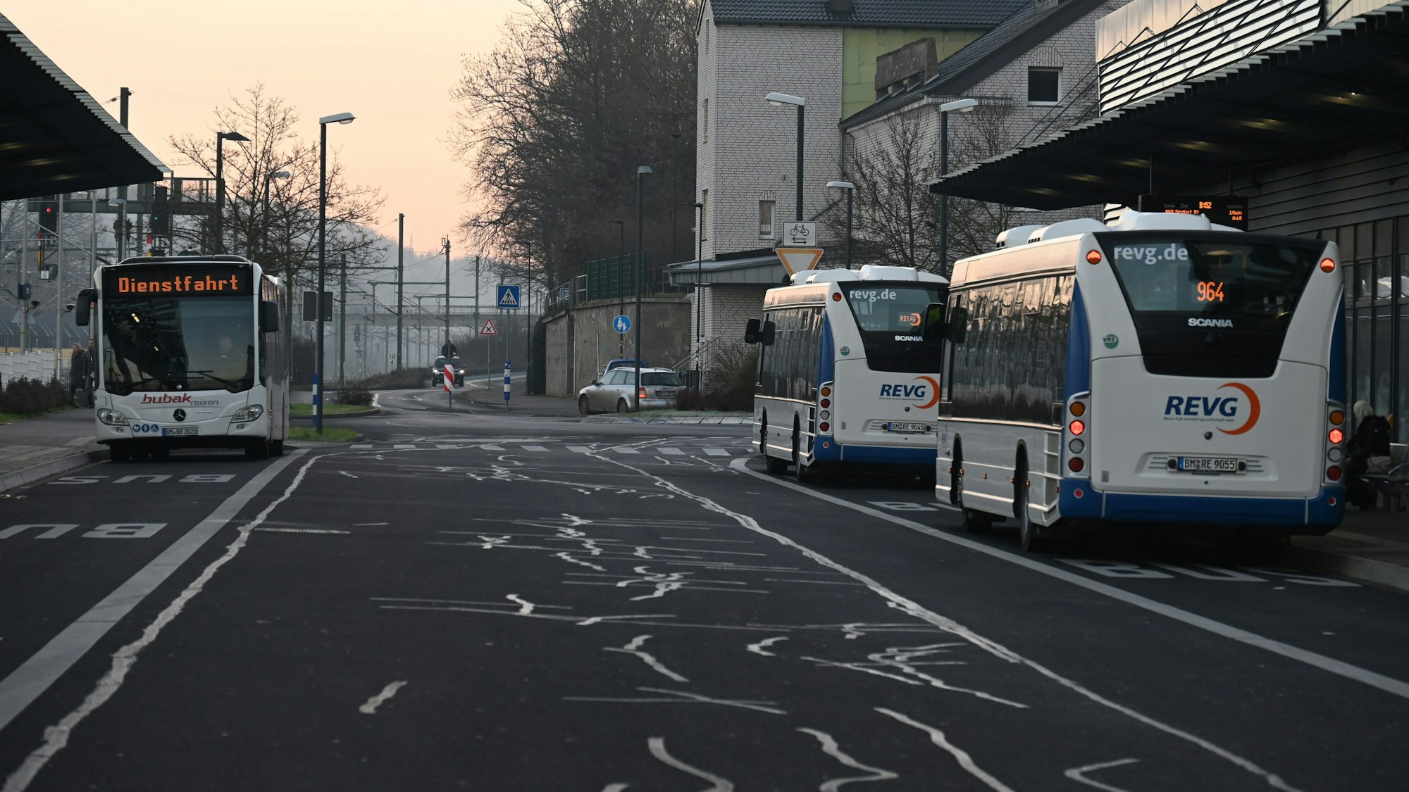Busse stehen am frühen Morgen an einem Busbahnhof.