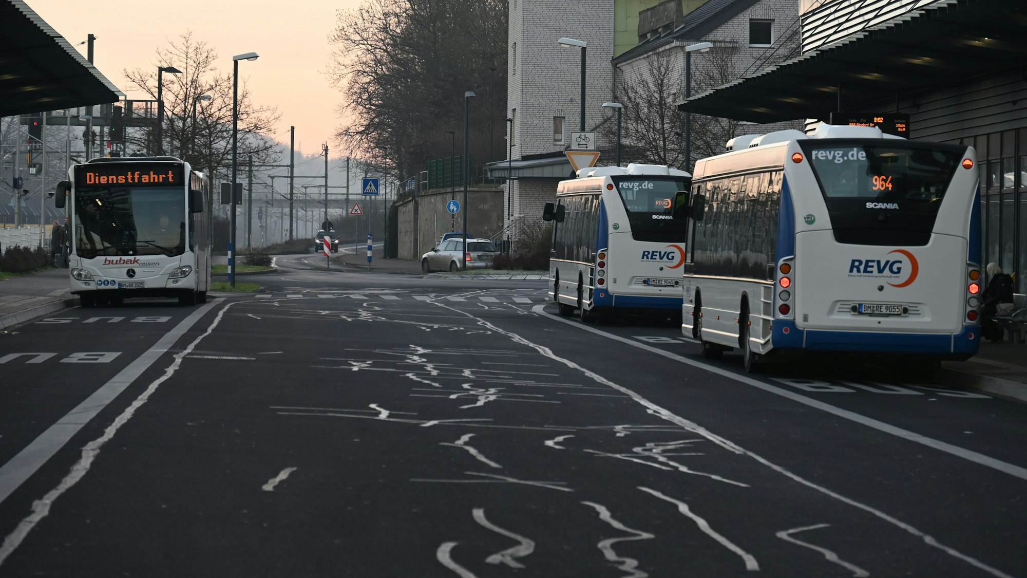 Drei Busse stehen an einem Busbahnhof.