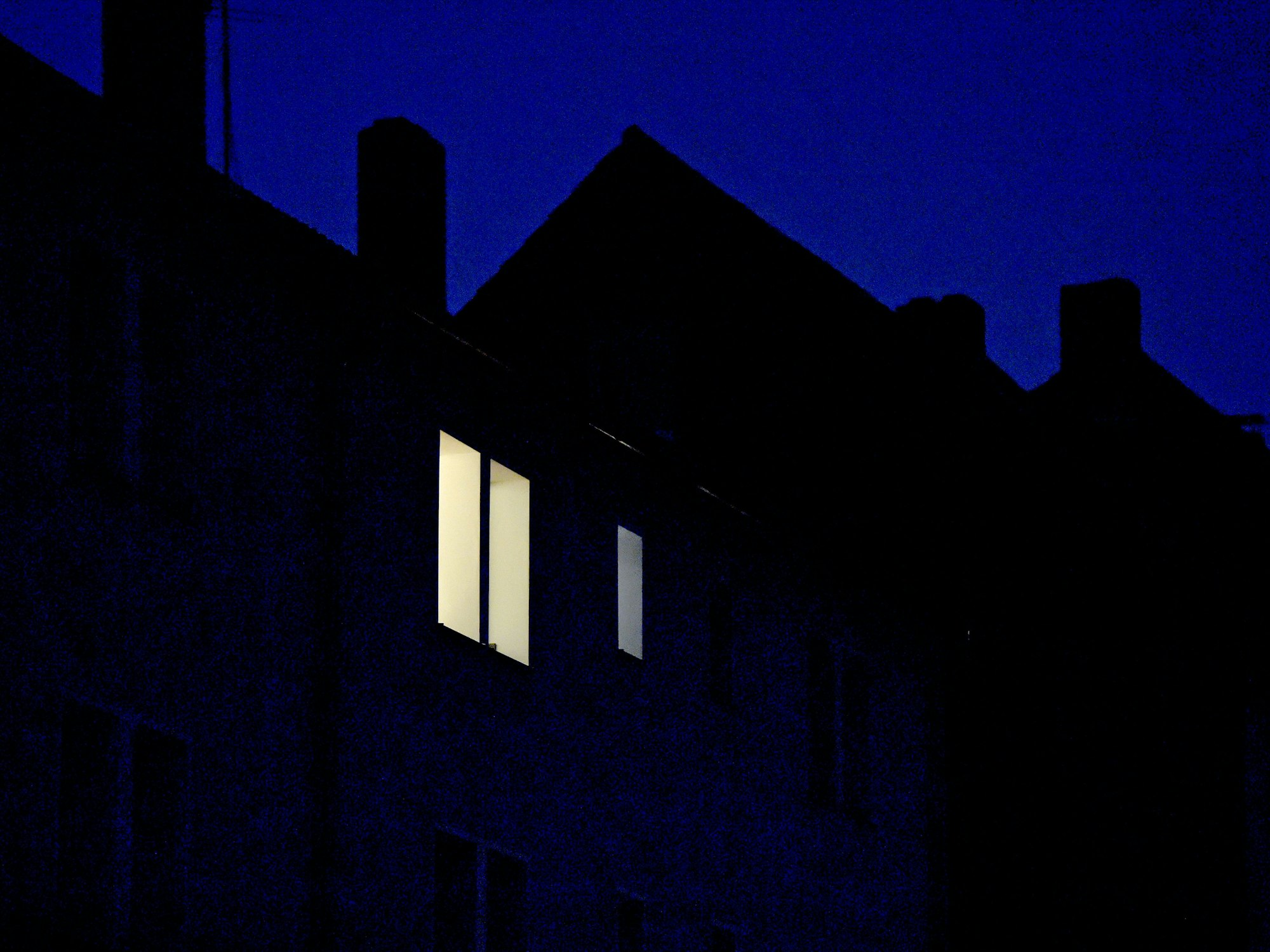 Zeugen hatten beobachtet, wie der Junge auf dem Dach herumkletterte. Unser Symbolfoto zeigt Licht in einer Wohnung im obersten Stock eines Hauses.