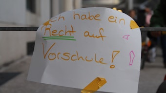 Ein Zettel mit der Aufschrift: „Ich habe ein Recht auf Vorschule!“, klebt am Geländer.