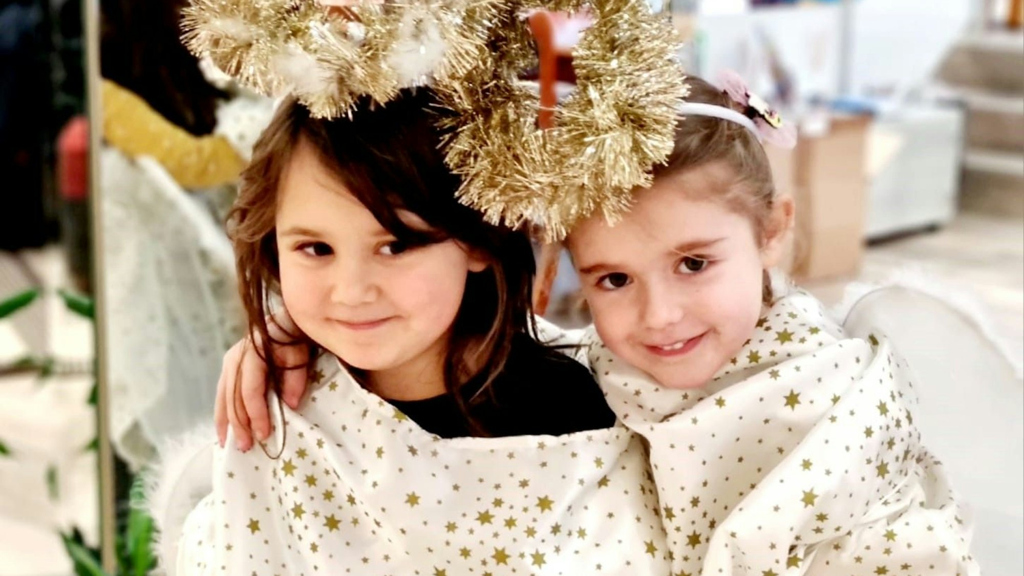 Zwei kleine Mädchen tragen ihre Engelkostüme.
