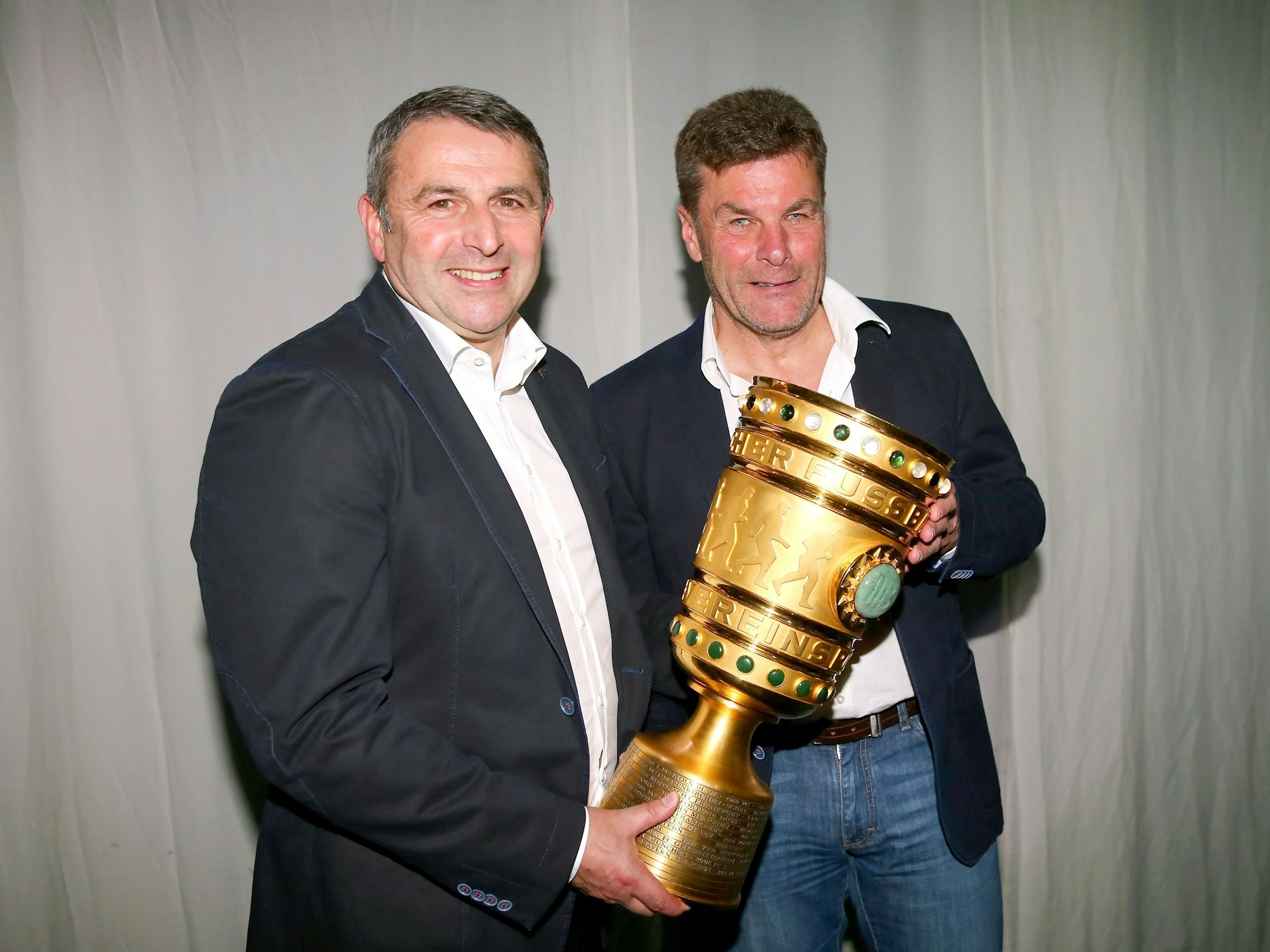 Klaus Allofs und Dieter Hecking halten den DFB-Pokal in den Händen.